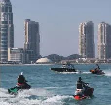  ??  ?? People ride jet-skis at Katara Beach in Doha. Qatar topped the global list of Covid-19 cases per million people AFP