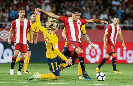  ??  ?? Going all out: Atletico Madrid’s Antoine Griezmann (third from left) vying for the ball with Girona’s Bernando Espinosa in the La Liga match at the Estadi Montilivi on Saturday. — AFP