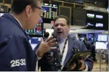  ?? RICHARD DREW — THE ASSOCIATED PRESS ?? Trader John Santiago, right, works on the floor of the New York Stock Exchange, Monday.