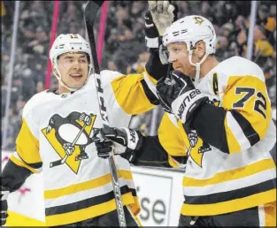  ?? LE Baskow The Associated Press ?? Penguins left wing Dominik Simon, left, celebrates a goal by right wing Patric Hornqvist against the Knights on Tuesday at T-Mobile Arena.