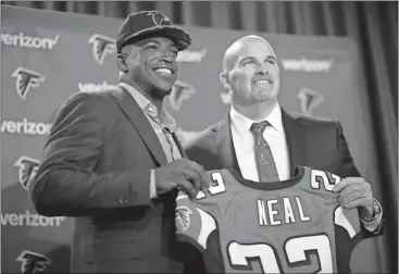  ??  ?? Atlanta Falcons first-round draft pick Keanu Neal (left) poses for a photo with his jersey and head coach Dan Quinn in Flowery Branch.