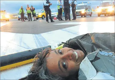  ??  ?? FLAT OUT: A campaigner smiles for the camera as she lies on the runway tarmac in protest over plans for a third runway at Heathrow.