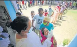  ?? PTI PHOTO ?? People waiting to get tested for Covid-19 at a government school in Jammu on Tuesday.