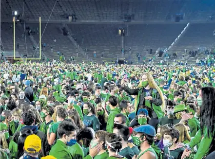  ?? Matt Cashore, pool photo via Getty Images ?? Fans storm the field after the Notre Dame Fighting Irish defeated the Clemson Tigers 47- 40 in double overtime at Notre Dame Stadium Saturday night in South Bend, Ind.