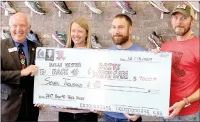  ?? Keith Bryant/The Weekly Vista ?? Standing and displaying a large check presented to the city of Bella Vista on Dec. 13 were Mayor Peter Christie (left), with Kelly Sikorski (president and founding member of Drive with Care), Mike Rush (owner of Rush Running), and James Reeves (who...