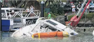  ?? PHOTO: NORTHERN ADVOCATE ?? Damage . . . A boat lies semisubmer­ged in the Tutukaka Marina after waves surged through the area from the Tonga volcanocau­sed tsunami and large swells from Cyclone Cody.