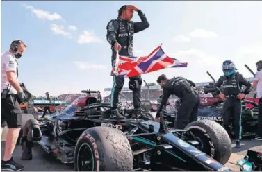  ??  ?? Lewis Hamilton sostiene la bandera británica con la que celebró su victoria en el GP de Gran Bretaña.