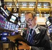  ?? MARK LENNIHAN / ASSOCIATED PRESS ?? Trader Gregory Rowe monitors stock prices Monday at the New York Stock Exchange. With $4.27 trillion in assets at the end of August, U.S. stock index funds edged past the $4.25 trillion in funds run by stock-picking managers.