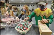  ??  ?? The Duncan family — (from left) father, Scott, and children, Ellie, Addie, Lexi and Evan — works Tuesday on a special Christmas bag assembly line in Rock Church in Yuma, Ariz. (AP/The Yuma Sun/Randy Hoeft)