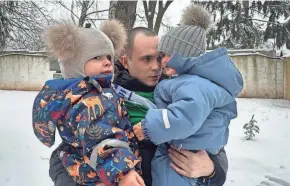  ?? VASILISA STEPANENKO/AP ?? After a prisoner exchange, Artem Dmytryk hugs his 2-year-old son, Timur, right, and a nephew in Kyiv, Ukraine, on Feb. 9.