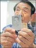  ?? AP ?? Lee Soonam shows photos of his North Korean brother Ri Jong Song.