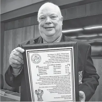  ?? KEVIN ADSHADE/THE NEWS ?? Coun. Peter Boyles displays a plaque about the Murray quintuplet­s, born in Hillside, Pictou County, in 1880.