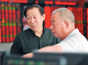  ?? AN XIN / FOR CHINA DAILY ?? Investors check out stocks at a brokerage in Fuyang, Anhui province.