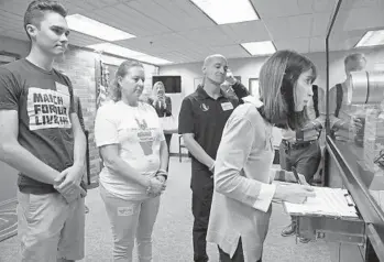  ?? AMY BETH BENNETT/SUN SENTINEL ?? Ban Assault Weapons Now Chairwoman Gail Schwartz signs paperwork as she submits petitions in February to the Broward County Supervisor of Elections office as part of a ballot initiative for a ban on the sale of military-grade weapons.