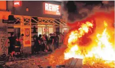  ?? FOTO: AFP ?? Ein Stadtteil in der Hand von Kriminelle­n: Randaliere­r plündern in der Nacht zum Sonntag einen Supermarkt im Schanzenvi­ertel.