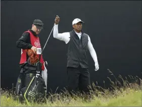  ??  ?? Tiger Woods of the United States get his club out of his bag on the 17th green during the second round of the British Open Golf Championsh­ips at Royal Portrush in Northern Ireland, on Friday. AP PHOTO/PETER MORRISON