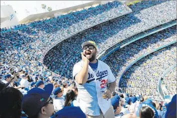  ?? Christina House For The Times ?? EDGAR PAEZ shouts over the crowd while watching the Dodgers play the San Diego Padres in L.A. The city took a get-tough approach to security this year, dispatchin­g more than 200 officers to the stadium.