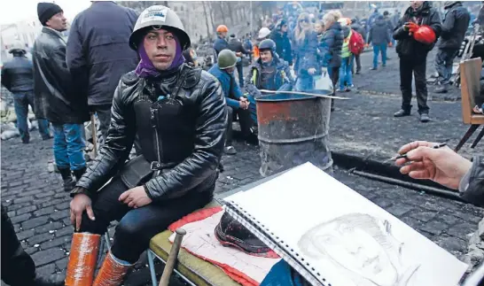  ?? Photo: REUTERS ?? New normal: An anti-government protester poses for a portrait in Kiev where the protest zone has once again acquired a good-natured feel despite the awful events of previous days.