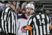  ?? DARRYL DYCK — THE CANADIAN PRESS VIA AP ?? Columbus Blue Jackets’ Boone Jenner, back, protests to referee Trevor Hanson, right, after a penalty was called against Andrew Peeke during the third period of an NHL hockey game Tuesday in Vancouver, British Columbia.