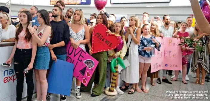  ??  ?? What a reception: Scores of Love Island fans await the contestant­s’ arrival at Stansted yesterday