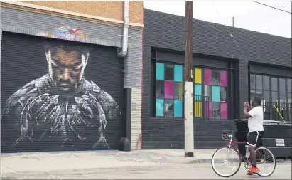  ?? CHRIS PIZZELLO — THE ASSOCIATED PRESS ?? A man stops to shoot a picture of a mural by artist Shane Grammer of late actor Chadwick Boseman’s character T’challa from the 2018film“black Panther” in Los Angeles. Boseman’s death is a reminder of how important preventati­ve care such as cancer screenings are, even during the current pandemic.