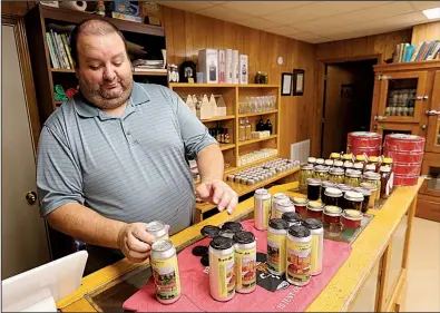  ?? NWA Democrat-Gazette/DAVID GOTTSCHALK ?? Patrick Richey, a brewery volunteer, assembles a four pack of beer Wednesday in the Country Monks Brewing taproom at Subiaco Abbey.
