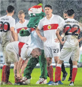  ?? FOTO: DPA ?? Stuttgarte­r Weihnachts­depression: Mario Gomez (Mitte) versteht die Welt nicht mehr, selbst Maskottche­n Fritzle vermag es nicht, die Spieler im Dauerregen zu trösten.
