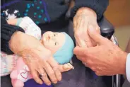  ?? CARLOS OSORIO/ASSOCIATED PRESS ?? A son, at right, holds his mothers hand as they talk at her nursing home in Adrian, Mich. Long-term care costs are still rising, according to a new report.