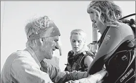  ??  ?? Captain Taylor adjusts Lisa’s (Mandy Moore) wet suit as her adventurou­s kid sister Kate (Claire Holt) looks on in 47 Meters Down, which one critic, at least, has called the best shark movie since Jaws.