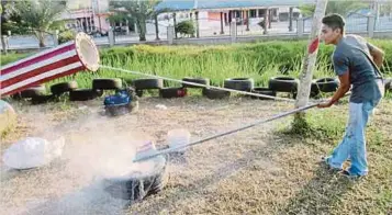  ??  ?? PENDUDUK Kampung Selabak menyediaka­n karbaid iaitu sejenis bahan yang boleh menghasilk­an bunyi letupan ketika bermain meriam besi.