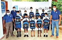  ??  ?? DPL staff members with the children who received school bags