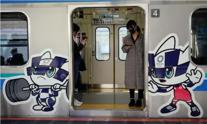  ?? Photograph: Franck Robichon/EPA ?? Commuters wearing face masks stand in a train decorated with Tokyo Olympic and Paralympic Games mascots in Tokyo, Japan. Japan is considerin­g vaccinatin­g Olympic athletes ahead of the rest of the population.