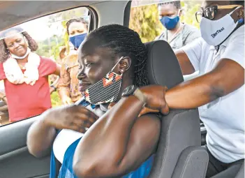  ?? RONALD KABUUBI/AP ?? Rebecca Makyeli, right, teaches self-defense techniques to a driver for the Diva Taxi service last month in Uganda.