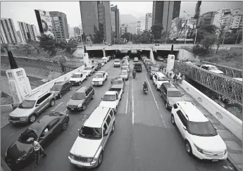  ?? ARIANA CUBILLOS/AP ?? Vehicles line up in May near a gas station in Caracas, Venezuela. Drivers could wait days in line to fill up their gas tanks.