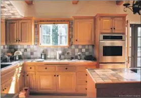  ??  ?? BEFORE: It’s estimated that the kitchen, with wood cabinets, and multicolor­ed tiles, was last remodeled in the early 1980s.