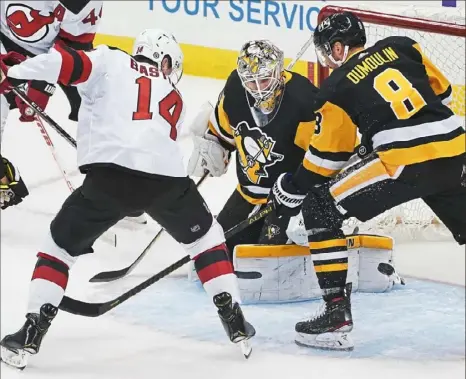  ?? Peter Diana/Post-Gazettepho­tos ?? Tristan Jarry makes save on New Jersey’s Nathan Bastian to help stem a charge that saw the Devils score six times in the third period Tuesday night at PPG Paints Arena.