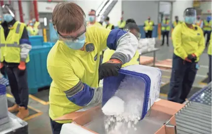  ?? MORRY GASH/ASSOCIATED PRESS ?? Dry ice is poured into a box containing the Pfizer-BioNTech COVID-19 vaccine as it is prepared to be shipped at the Pfizer Global Supply Kalamazoo manufactur­ing plant in Portage, Mich., on Sunday.