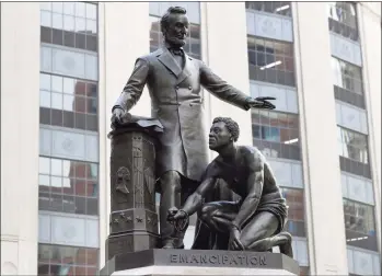  ?? Steven Senne / Associated Press ?? In this file photo, a statue that depicts a freed slave kneeling at President Abraham Lincoln's feet rests on a pedestal in Boston. On Tuesday, the statue was removed from its perch.