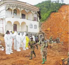  ?? FOTO: AFP ?? Rettungskr­äfte und Soldaten beim Einsatz in der Nähe von Freetown: Noch immer ist unklar, wieviele Tote es gibt.