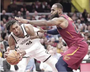  ??  ?? Rondae Hollis-Jefferson, de los Nets de Brooklyn, intenta pasar el baló ante la defensa de LeBron James, de los Cavaliers de Cleveland, en la primera mitad del partido de anoche en la NBA.