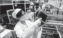  ?? Chinatopix ?? A WORKER checks solar panels at a factory in China’s Jiangxi province. The Biden administra­tion is expected to announce the new tariffs on Tuesday.