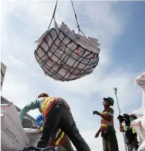  ?? REUTERS ?? A WORKER looks up at the batch of imported Vietnamese rice being unloaded at a port in Manila on August 18, 2014.