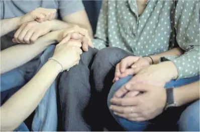  ?? Jordi Cotrina ?? Montse, que padece alzhéimer, es cogida de las manos por sus tres hijos, en Barcelona.