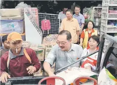  ??  ?? Dr Sia (front, right) and others helping to load items for the fire victims onto a lorry.