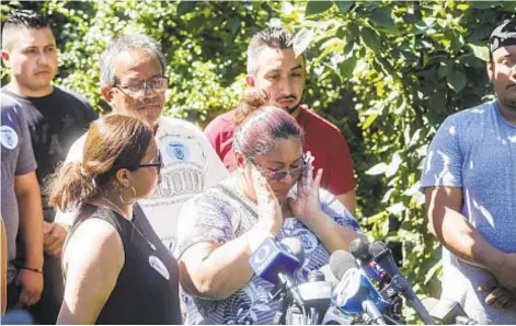  ?? BYRON SMITH ?? Concepcion Silva wipes tears from her eyes Thursday in Brooklyn as she talks about being held in detention by ICE with her husband, Margarito (back, left).