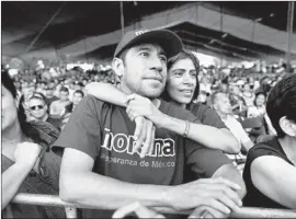  ??  ?? MIGUEL GOMEZ TORRES and his wife, Emma, listen as Lopez Obrador addresses a rally. Voters are fed up with the long-ruling PRI party and its rival PAN.