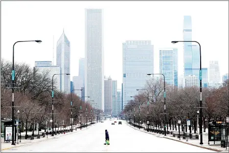  ??  ?? An elderly lady walks across the usually busy Columbus Drive that splits Chicago’s Grant Park in half, on the first work day since Illinois Gov J.B. Pritzker gave a shelter in place order last week in this March 23 photo, in Chicago. Gov J.B. Pritzker says Illinois is not receiving enough medical supplies in its fight against the coronaviru­s. Pritzker tells CNN’s ‘State of The Union’ that Illinois got a recent supply but it was a fraction of what was requested from the federal government. The comments prompted angry tweets from President Donald Trump who says governors should not be ‘blaming the federal government for their own shortcomin­gs.’ (AP)