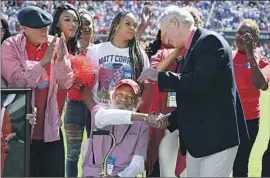  ?? Thomas Graning Associated Press ?? FOOTBALL FANS take time out Saturday to focus on James Meredith, seated, in one of several events marking 60 years since he forced Ole Miss’ racial integratio­n.