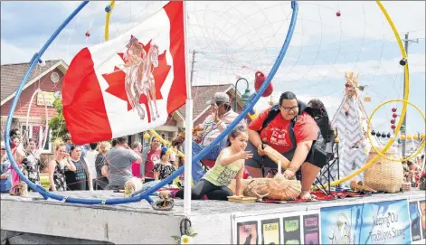  ?? DESIREE ANSTEY/JOURNAL PIONEER ?? Lennox Island Coun. Janet Bernard hands out candy with helpers on the dream catcher float during St. Anne’s Sunday activities in Lennox Island.