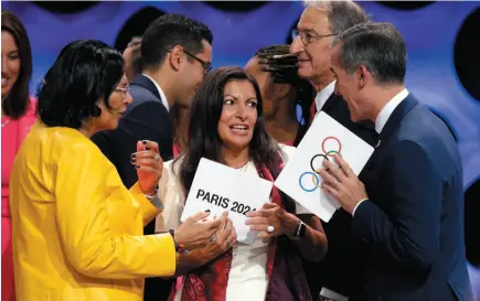  ?? AP PHOTO ?? Paris Mayor Anne Hidalgo, center, speaks with Los Angeles Mayor Eric Garcetti, right, and Los Angeles Internatio­nal Olympic Committee member Anita DeFrantz, left, at the end of the IOC session in Lima, Peru on Wednesday.